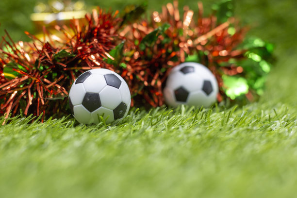 足球圣诞节假期与球和圣诞节装饰在绿色的草地背景图片下载