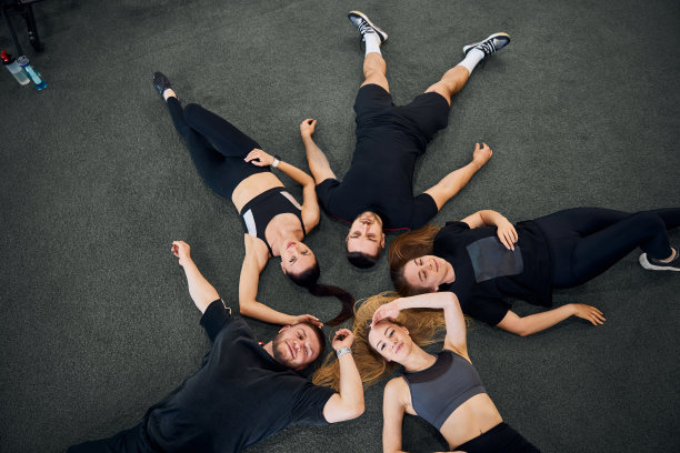 穿着运动服在健身房地板上摆姿势的健康人图片下载