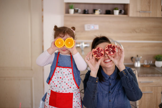 母女俩玩水果玩得很开心。库存图片图片下载