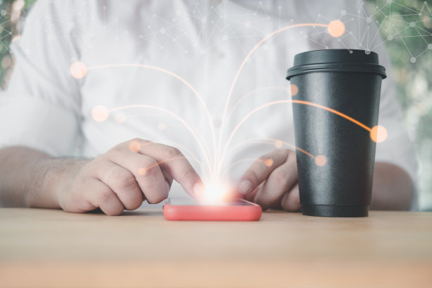 男人使用智能手机连接技术接口和一杯热咖啡。创新技术的概念。图片下载