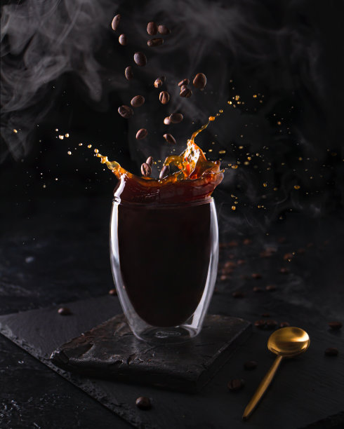 早上用玻璃杯盛着的热浓缩咖啡。在黑色的背景上，香气四溢的咖啡和蒸汽飞溅而下。旗帜设计图片下载