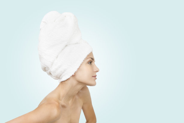 头上缠着毛巾的年轻女孩。美学的概念。图片下载