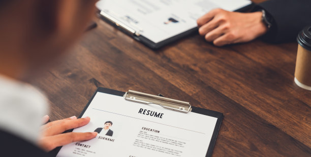 女商人向雇主提交简历，在办公桌上查看求职申请信息，展示公司同意该职位的能力。图片下载