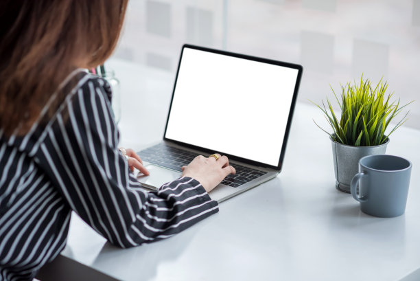 关闭了。在桌上的白色屏幕上使用笔记本电脑的女商人。模拟。素材图片