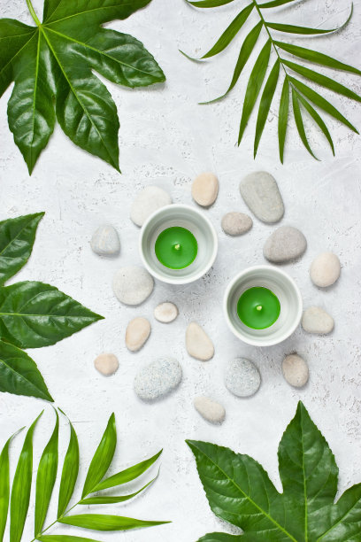 温泉概念-蜡烛，石头和绿叶在光明的表面，平躺图片下载