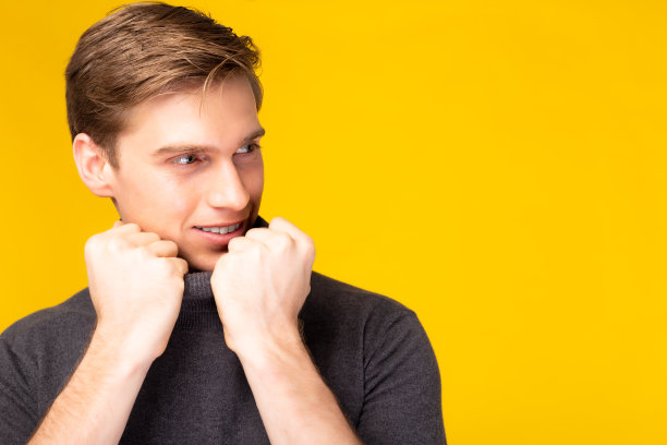 肖像年轻英俊的白人男子姿势微笑看着复制空间工作室拍摄孤立在黄色背景有吸引力的英俊男子得到自信和迷人的时尚和发型概念图片下载