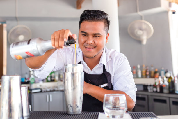 调酒师正在吧台做鸡尾酒。图片下载
