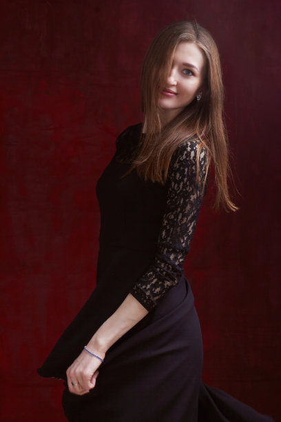 一个年轻女子的肖像与棕色长发，在一个红色纹理的背景图片下载