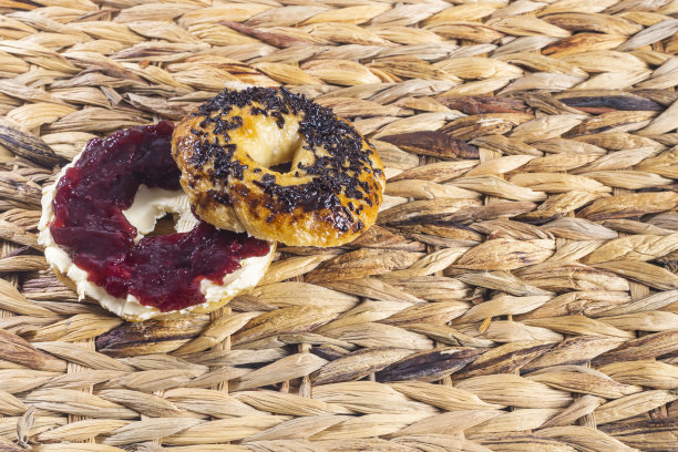 新鲜烘焙的百吉饼配上奶油芝士和草莓酱。糕点和家庭烹饪概念。水平照片和选择焦点图片下载