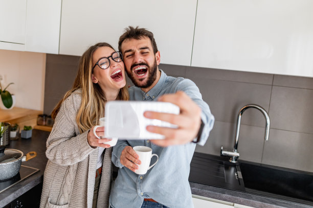 年轻夫妇在家里用手机自拍图片下载