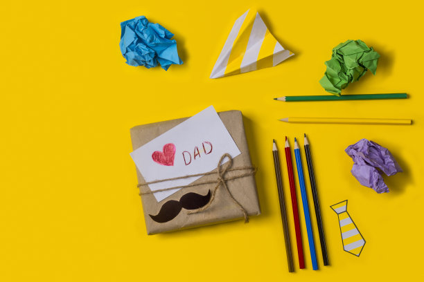 礼物盒与一张便条爱你爸爸在黄色的背景与铅笔和纸与复制空间。平的。孩子给爸爸的父亲节礼物。父亲节节日理念快乐图片下载