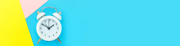 响双铃经典闹钟孤立在蓝黄粉彩色几何背景。休息小时，生活时间，早安，晚安，醒来，清醒的概念。平放俯视图拷贝空间图片下载