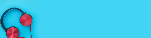 蓝色的旗帜。蓝色背景上的红色耳机。极简简单的照片耳机与复制空间。红色dj耳机孤立在柔和多彩的背景，平躺顶视图。音乐的概念图片下载