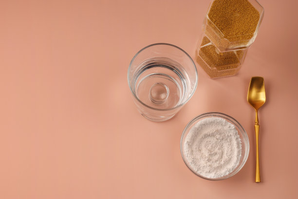 天然水解美容胶原蛋白补充嫩肤。金沙漏和粉勺。粉色背景下的健康抗衰老放松理念。从以上观点。本空间图片下载