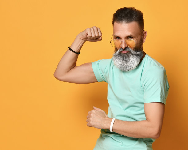 野蛮的大胡子男子展示肌肉力量手势工作室拍摄图片下载