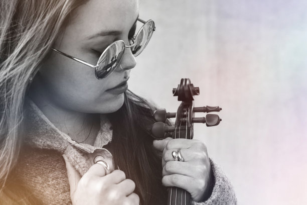 一个戴着墨镜拿着小提琴的白人女性的灰色照片图片下载