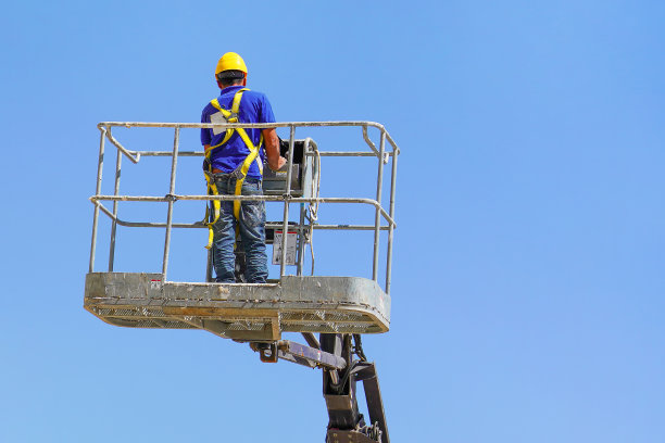 在升降车中的戴安全帽及安全设备的工人图片下载