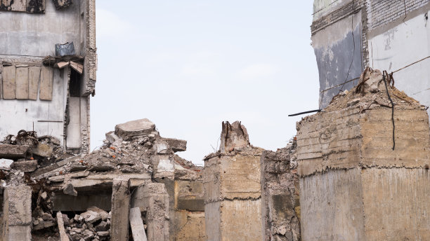 前景是一座废墟建筑的遗迹，上面有很大的地基桩。背景图片下载