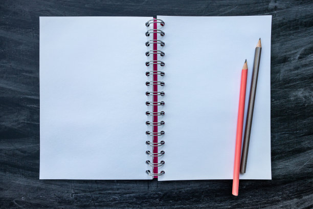 黑板背景上的空白螺旋笔记本图片下载