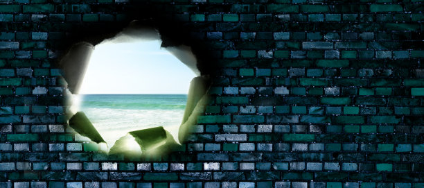 砖墙上有个洞，可以看到海滩图片下载