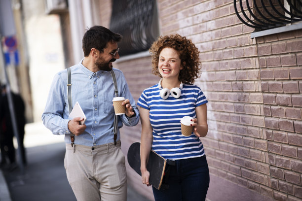 快乐的女人和男人走在城市里。库存图片图片下载