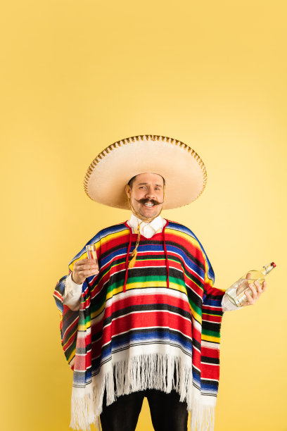 快乐的人的肖像在明亮的衣服，雨披孤立在黄色的背景图片下载