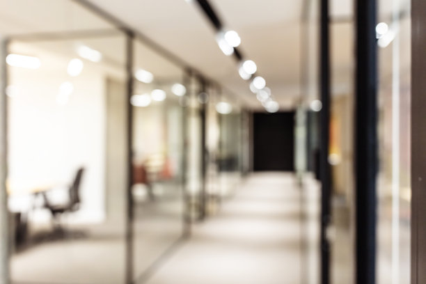 散焦办公背景，玻璃隔断和办公桌的开放空间图片下载