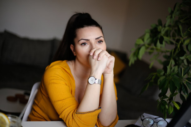 疲惫的女商人在办公室里拿着笔记本电脑。库存图片图片下载