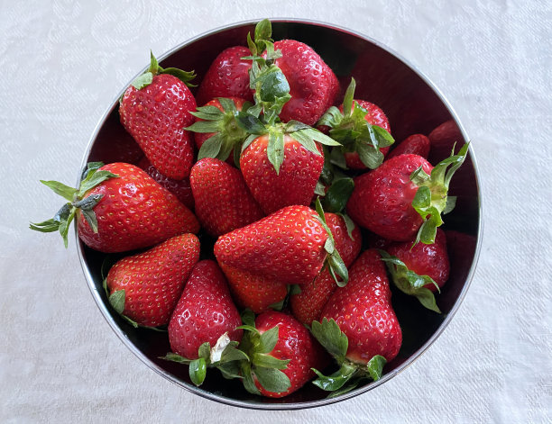 桌上的银碗里放着成熟的新鲜草莓图片下载