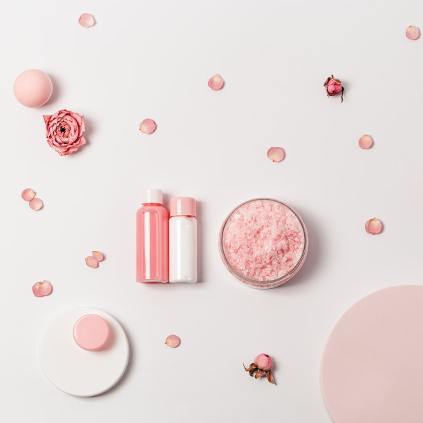 玫瑰香海盐和小瓶沐浴露，肥皂和玫瑰花在圆形讲台上。化妆品俯视图图片下载