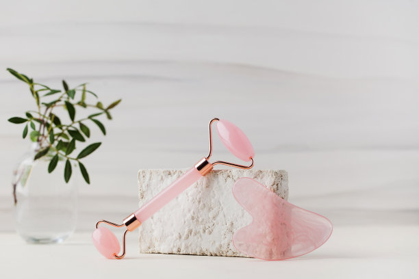 玫瑰石英刨沙石，玉辊上有光亮的背景。家居护肤的概念。图片下载