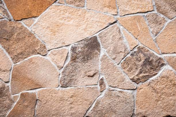 褐色的石墙纹理，粗犷的背景，抽象的马赛克图案，岩石表面，肮脏粗糙的花岗岩。建筑的立面。自然纹理背景，设计元素。复古砖。图片下载