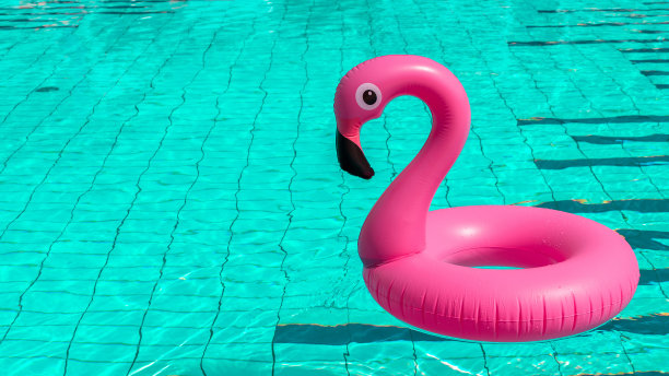夏天出售。粉红色的充气火烈鸟在游泳池的水为夏天的海滩背景。最小的夏天的概念。图片下载
