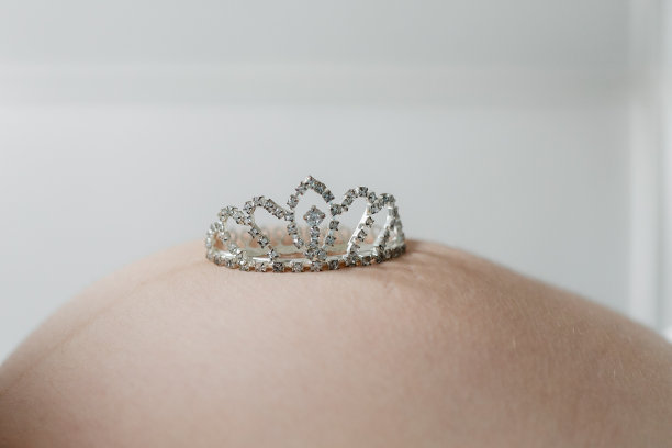 怀孕宝宝肚子新生期望。玩具皇冠在腹部图片下载