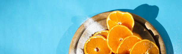 橘片放在圆木板上。明亮的青绿色背景。为文本复制空间。横幅。图片下载