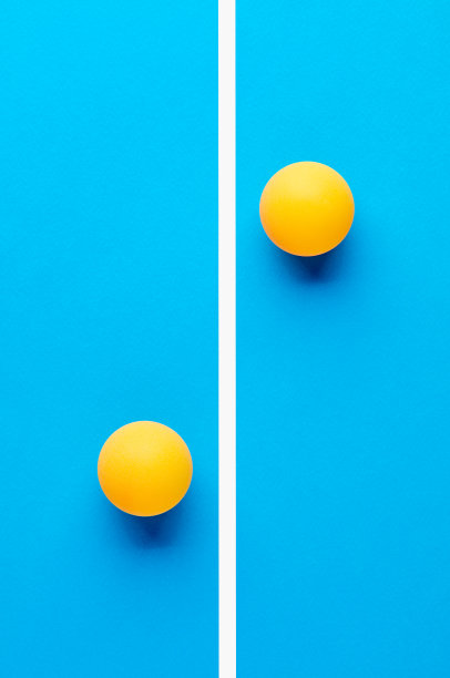 两个橙色的乒乓球互相对立，被蓝色背景上的一条线分开。图片下载