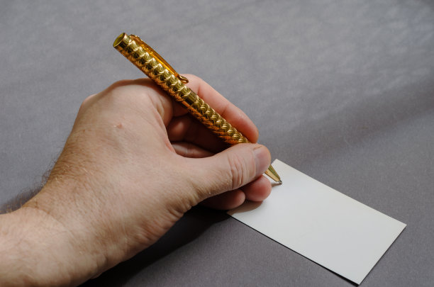 广告,商业概念。灰色背景上的手、笔和名片。图片下载