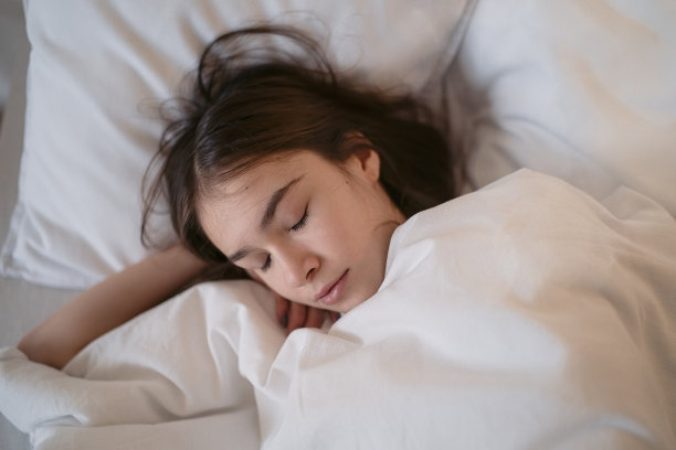 睡在白色枕头上的少女图片下载