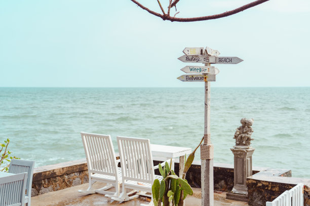 白色木制标志和木制椅子在热带海滩和海洋的背景。夏天的概念。图片下载