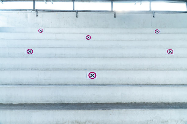 大看台体育场，有十字标志，以保持社交距离。室内体育场看台上有红黑十字标志，表示坐着不受冠状病毒或冠状病毒感染图片下载