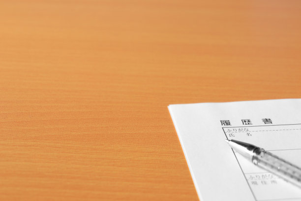 桌上放着一份空白的简历和一支笔。图片下载