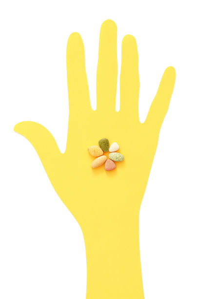 彩色维生素纸上黄色手俯视图上白色背景图片下载