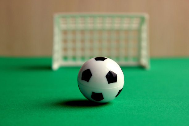 足球。灰色背景上的一个小门里的足球。迷你足球。体育游戏。球在大门附近。复制的空间。健康、活跃的户外活动。图片下载