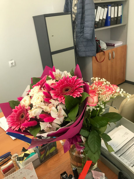 办公室的工作桌上放着一束节日的美丽的春天鲜花图片下载