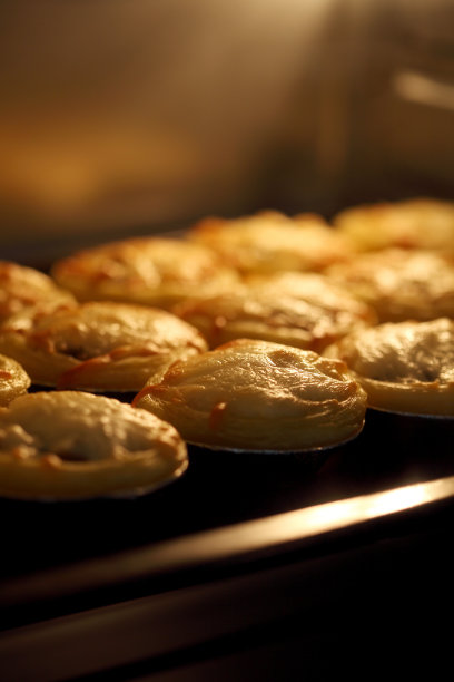 迷你馅饼由肉类和蘑菇在工业烤箱中烘烤，馅饼和糕点批发面包店工厂图片下载
