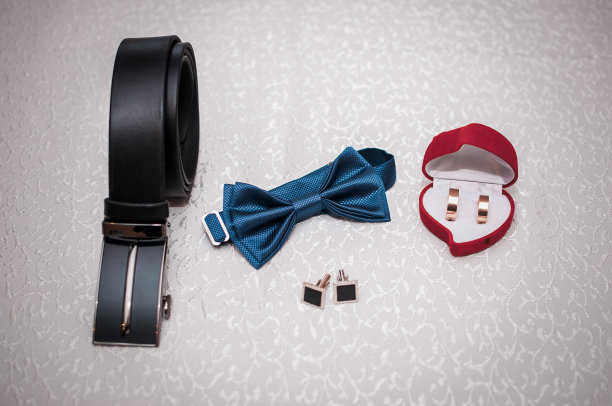 新郎的装饰品和结婚戒指放在桌上图片下载