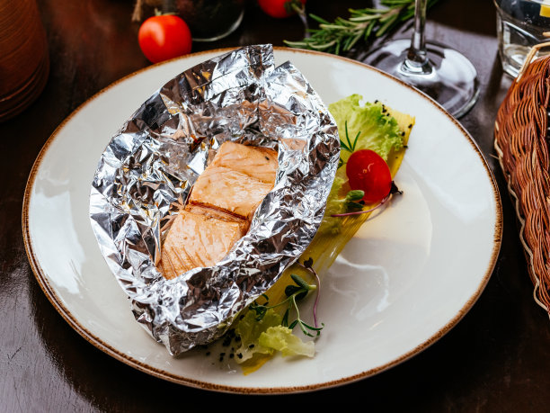 盘子里的烤鱼配上蔬菜和酱汁图片下载