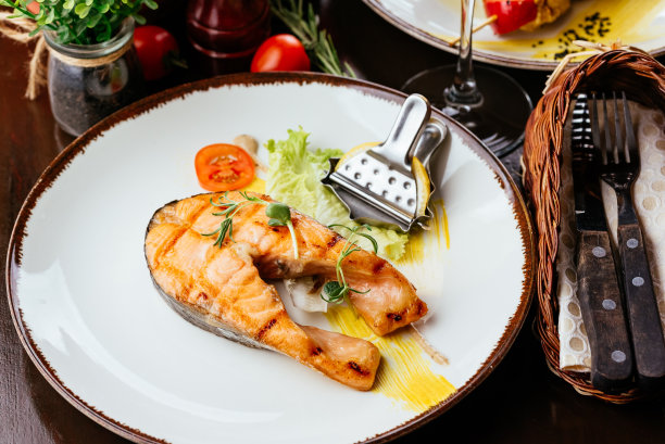 盘子里的烤鱼配上蔬菜和酱汁图片下载