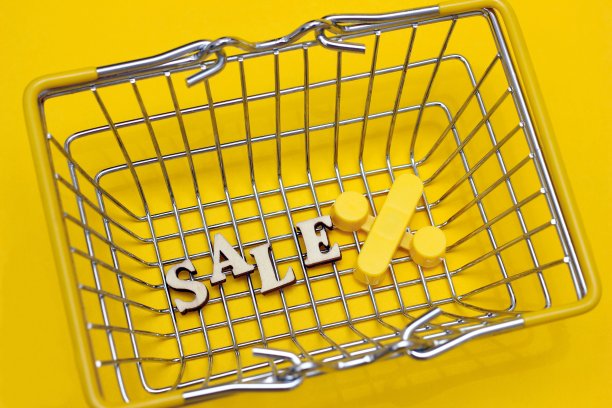 小购物篮的底部有几个字母写着“特价”。百分号在它旁边。圣诞节的在线商店。冬季假期促销、季节性促销或黑色星期五促销。图片下载