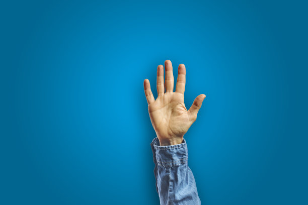 在蓝色背景下，女人张开手做手势图片下载